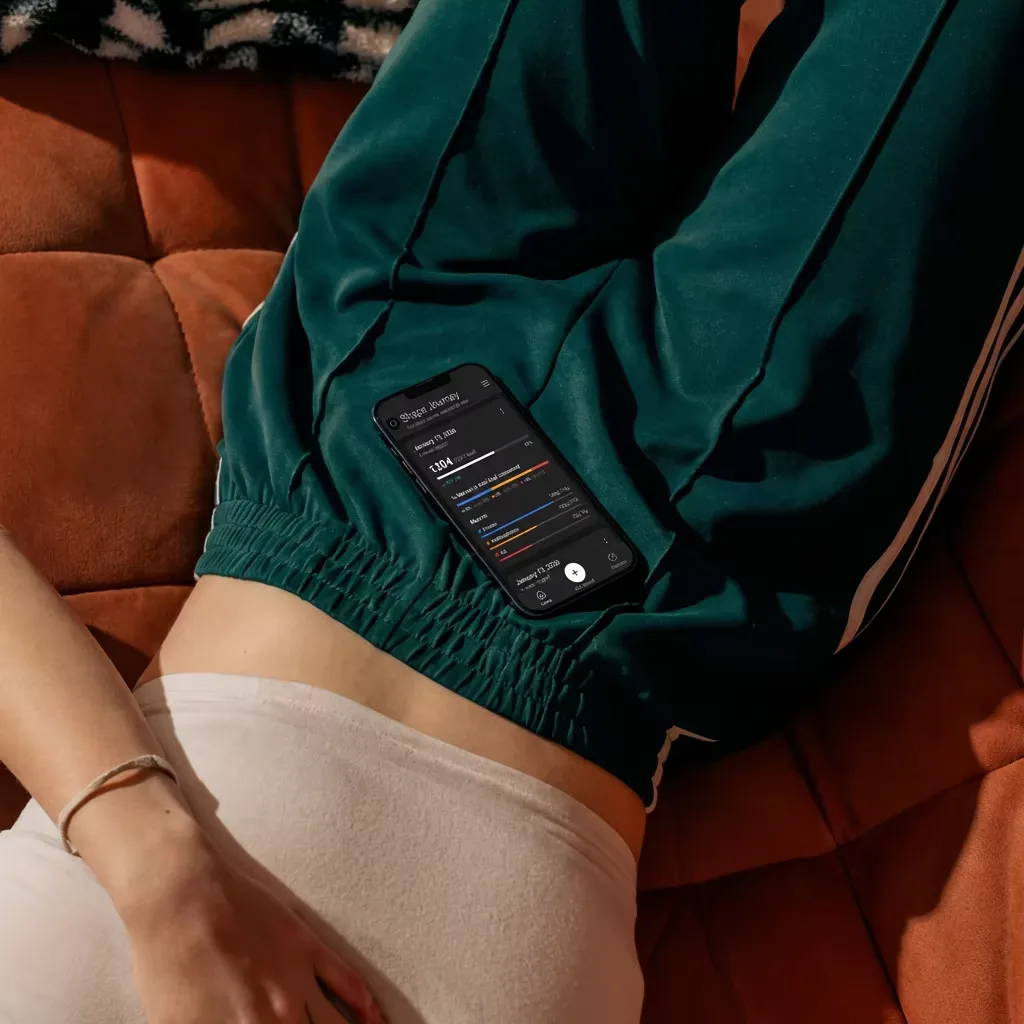 Cinematic shot of a fit person resting after workout, wearing dark green athleisure, looking at a smartphone with fitness app, dark moody lighting, high contrast, editorial style